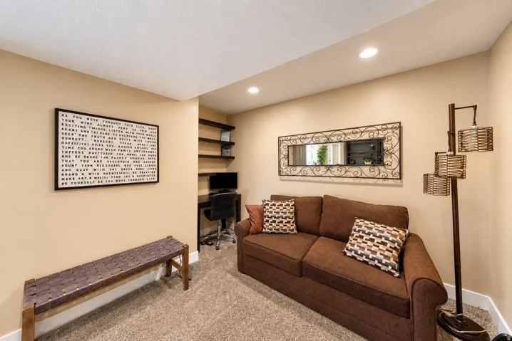 Recessed lighting, neutral wall tones, built-in shelving, desk alcove, and carpet flooring