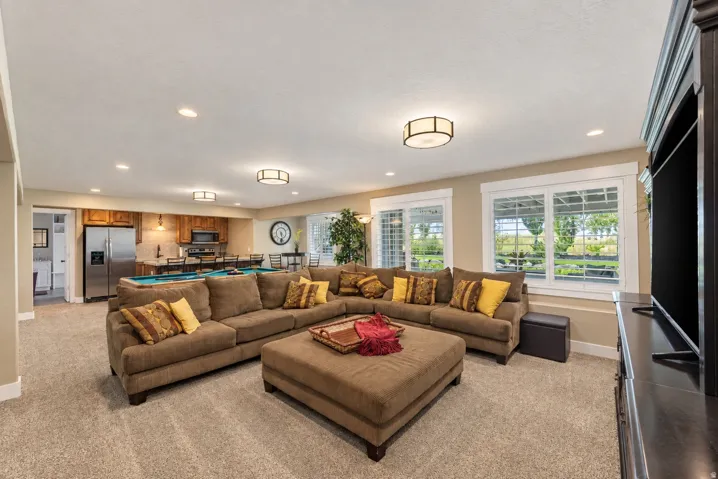 Spacious open-concept room featuring carpet flooring, recessed lighting, and multiple windows