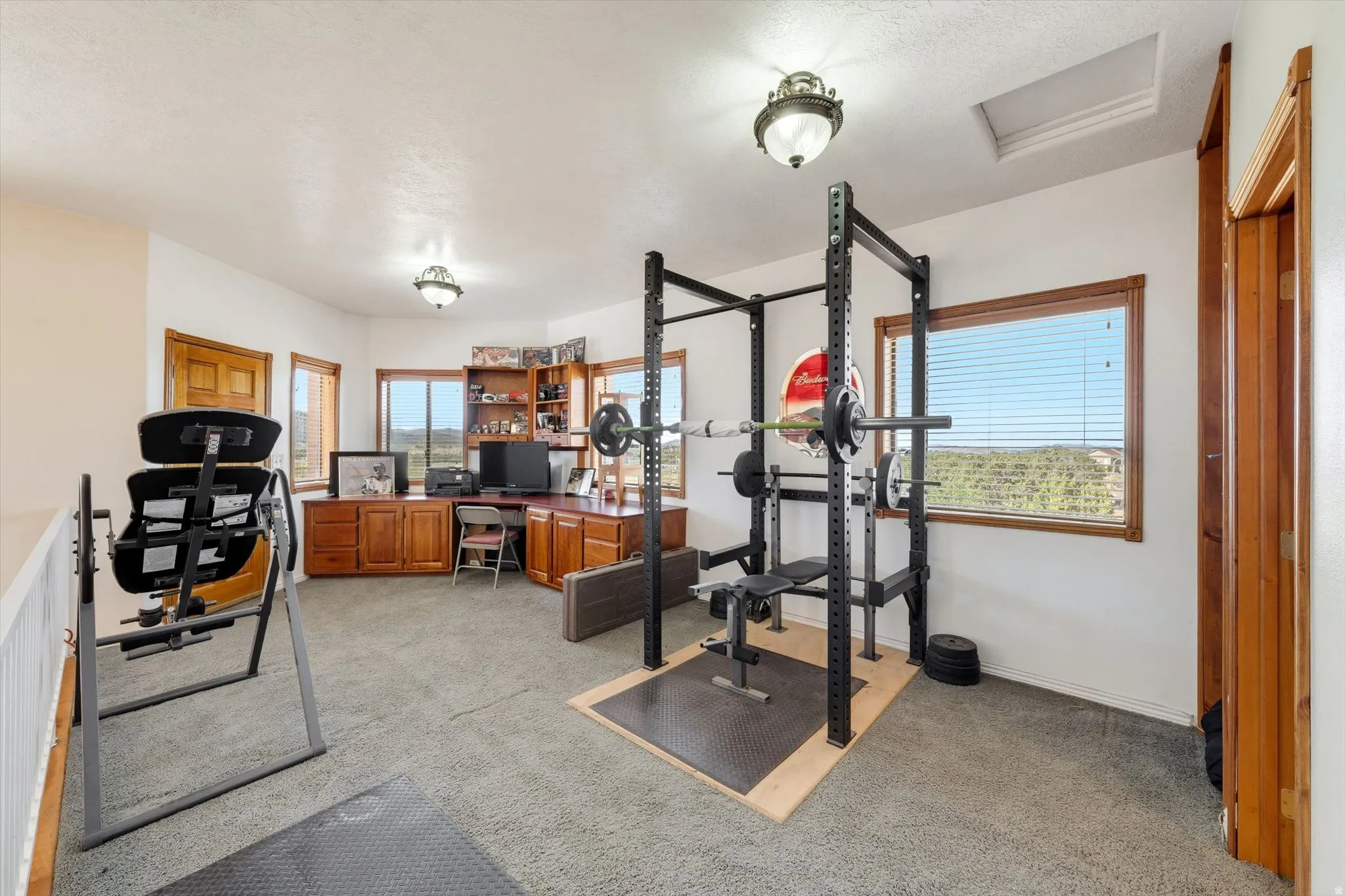 Loft space featuring wood-finish window trim, built-in wood cabinetry, and recessed lighting