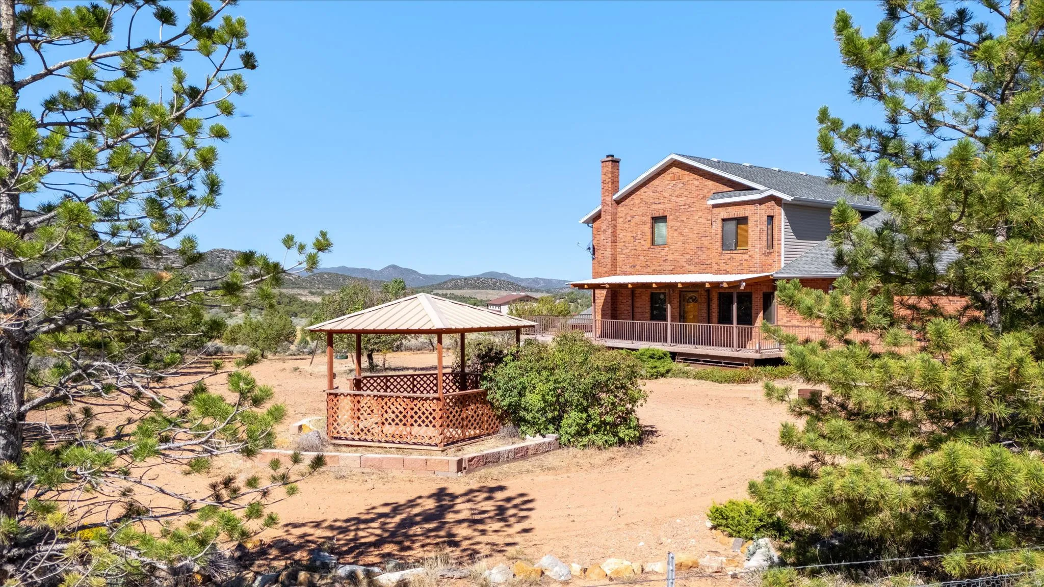 Brick exterior residence with a covered porch and an outdoor gazebo