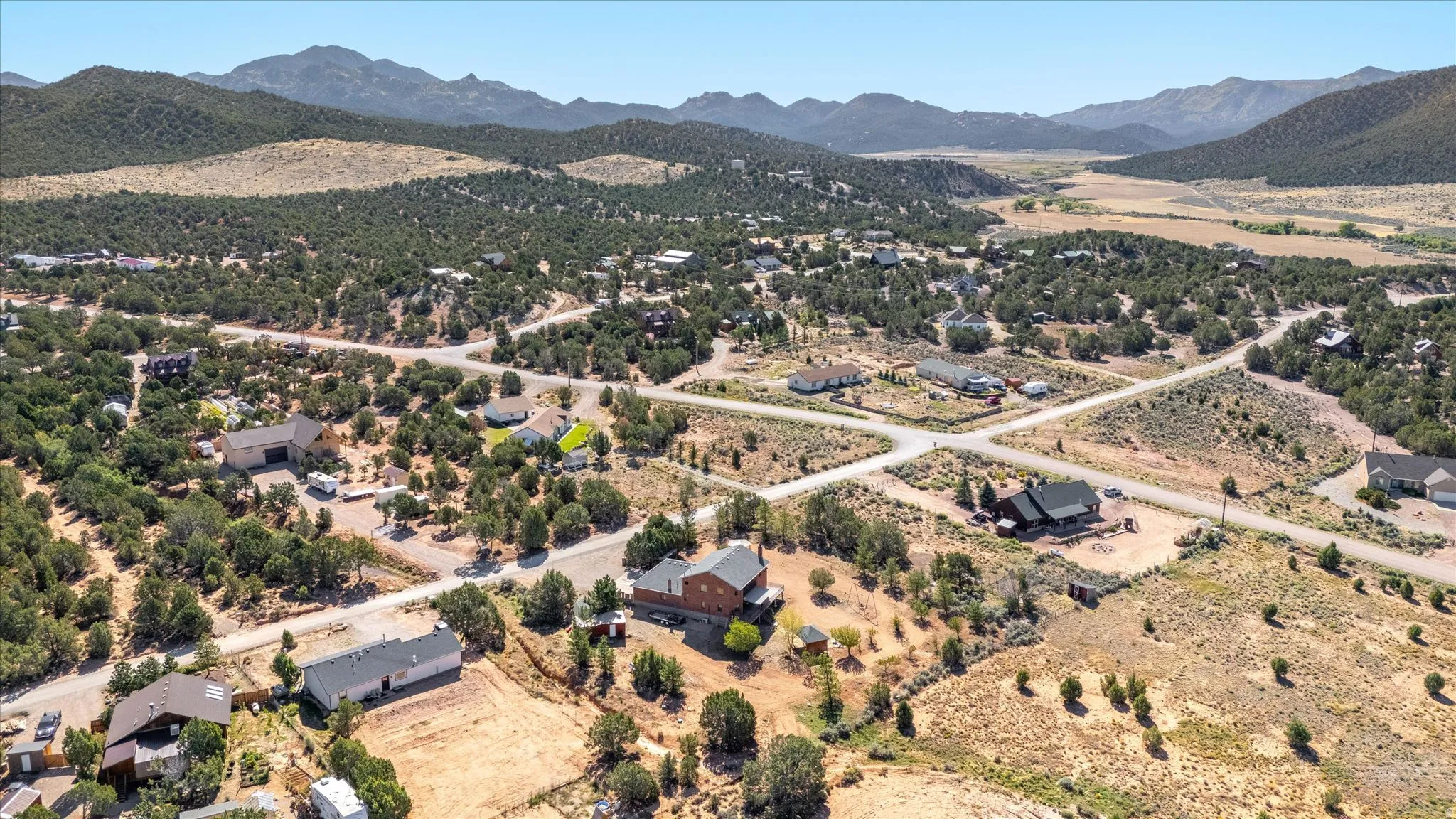 Expansive mountain landscape with scattered residential properties and established roadways
