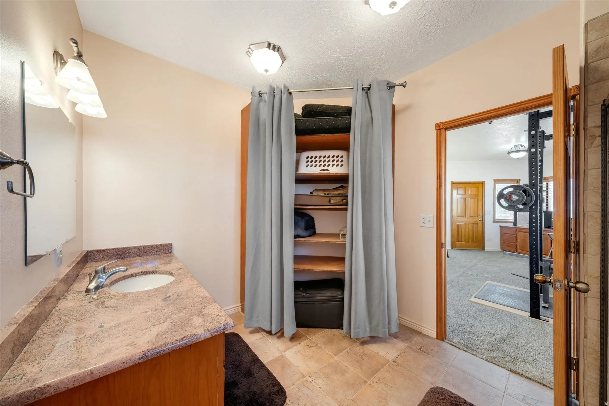 Vanity with stone countertop, undermount sink, and chrome faucet