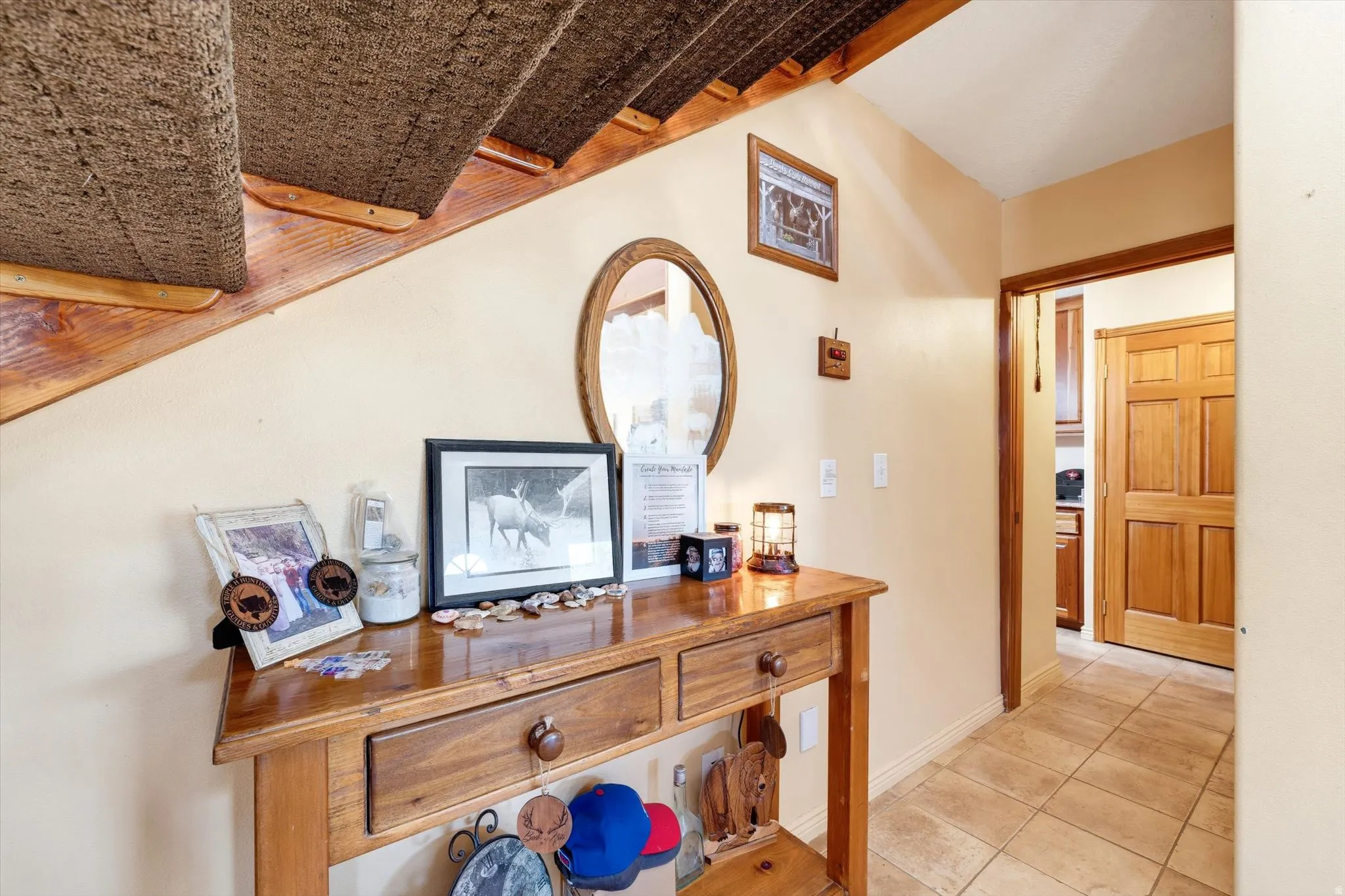 Staircase with carpeted treads and wood risers, a wood-paneled door, and tiled flooring