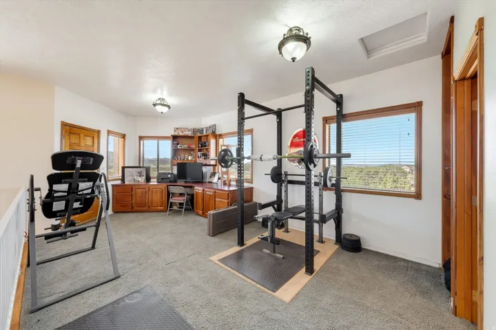 Loft space featuring wood-finish window trim, built-in wood cabinetry, and recessed lighting