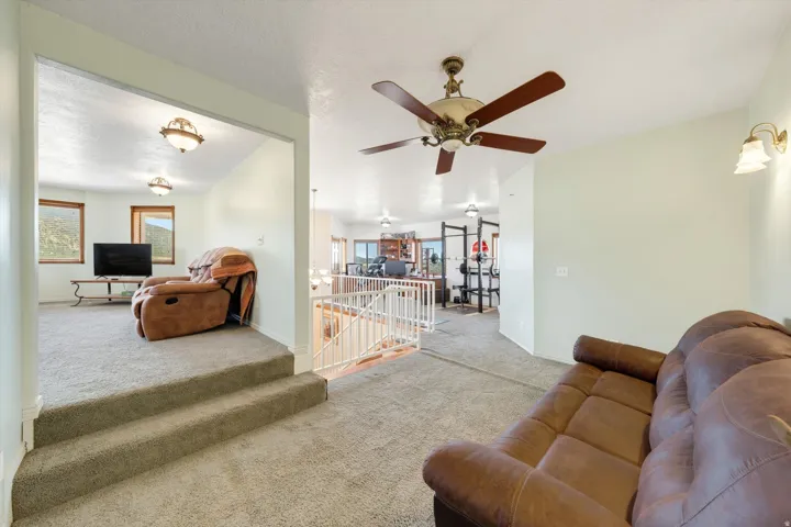 Carpeted flooring throughout, recessed lighting, and a ceiling fan with integrated lighting