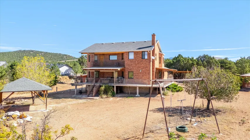 Brick exterior residence with a multi-level deck, covered outdoor living space, and a detached gazebo
