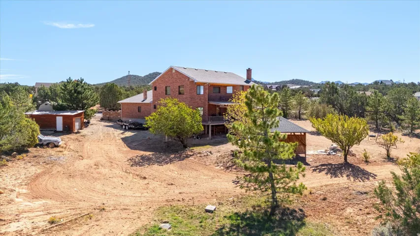 Brick exterior residence with multiple levels, an attached deck, and a detached outbuilding