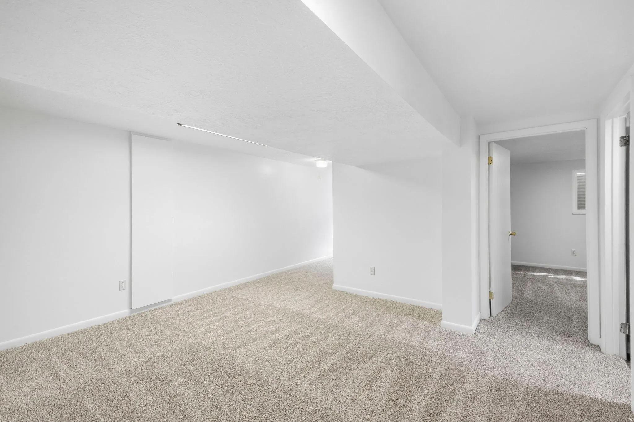 Neutral-toned carpet flooring and white painted walls create a bright interior