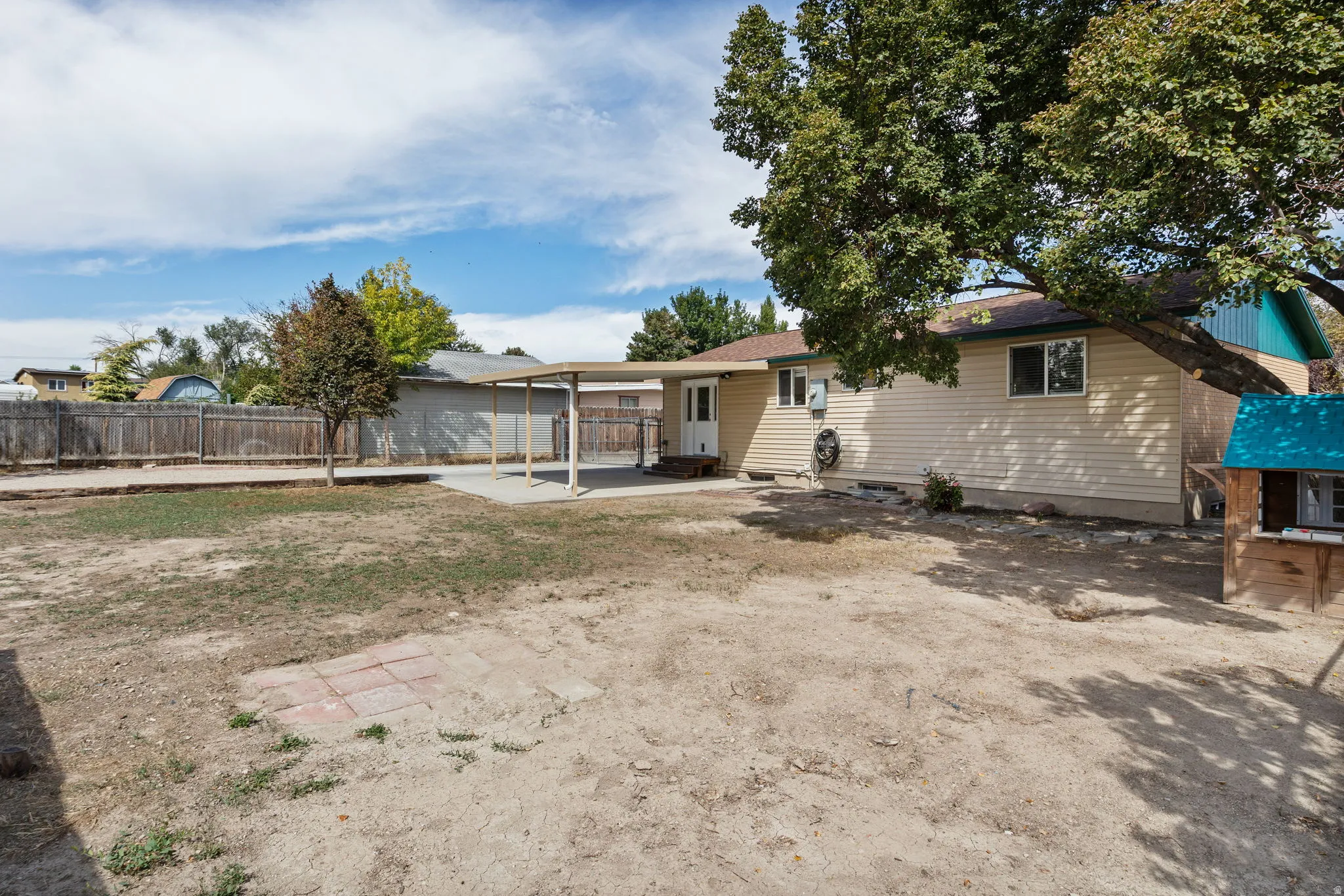 Expansive backyard featuring a covered patio, rear entry, and mature trees