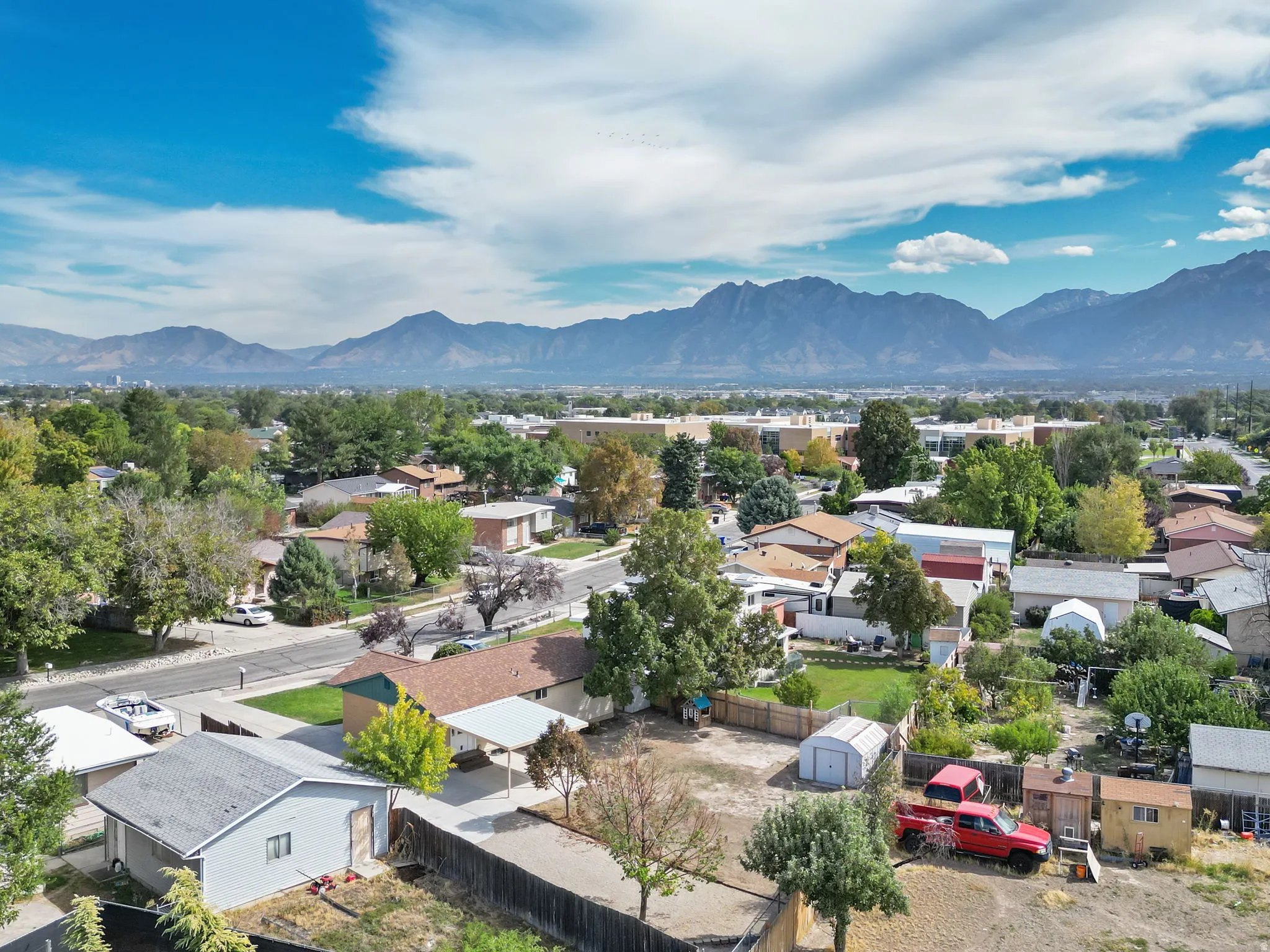 Residential neighborhood with established trees and mountain backdrop