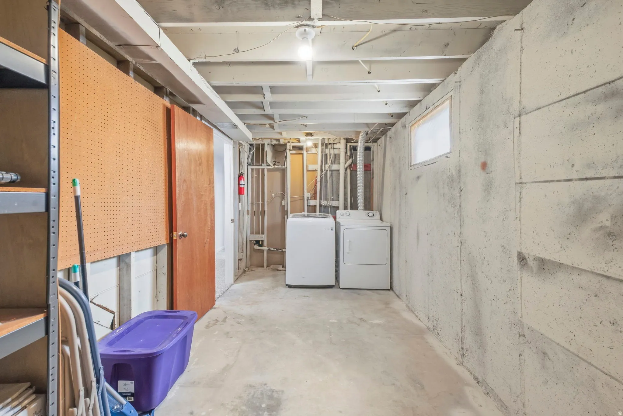 Concrete flooring, exposed ceiling joists, and a utility window