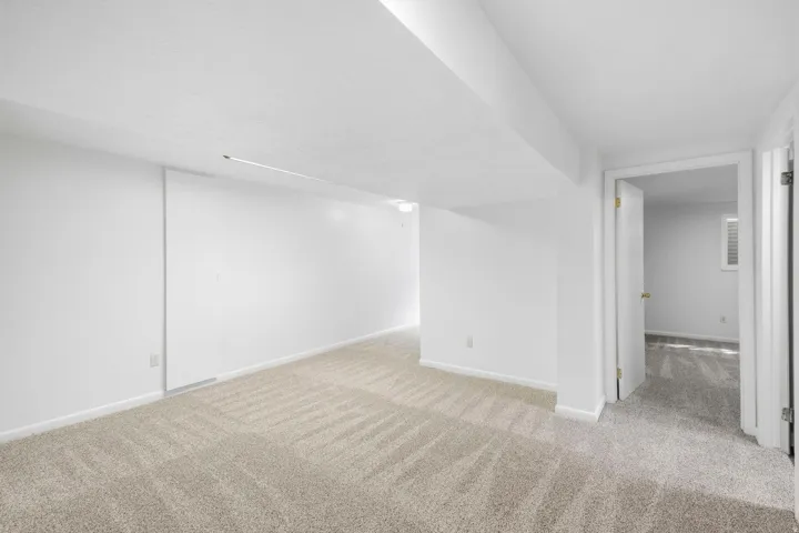 Neutral-toned carpet flooring and white painted walls create a bright interior