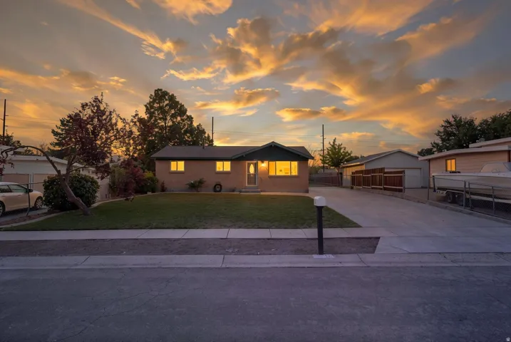 Single-story residence featuring a front lawn and paved driveway