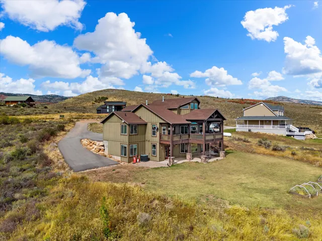 Multi-level residence featuring a covered balcony, and a paved driveway