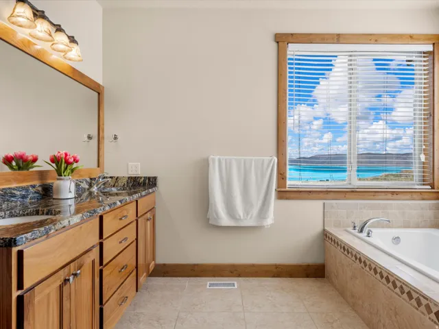 Dual sink vanity with stone countertop and wood cabinetry