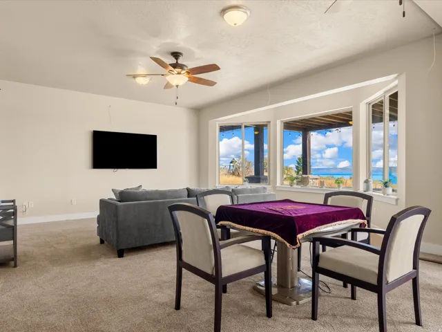 Carpeted living area with a ceiling fan, recessed lighting, and a bay window