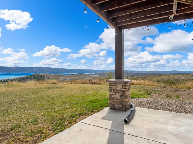 Covered patio featuring a concrete surface and stone-clad support pillar