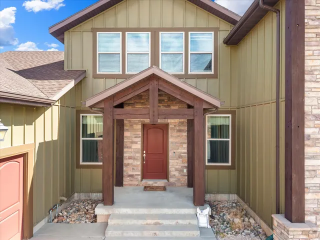 Green vertical siding exterior with a brown shingled roof