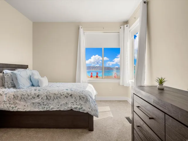 Carpeted room with a dark wood-finish bed frame and matching dresser