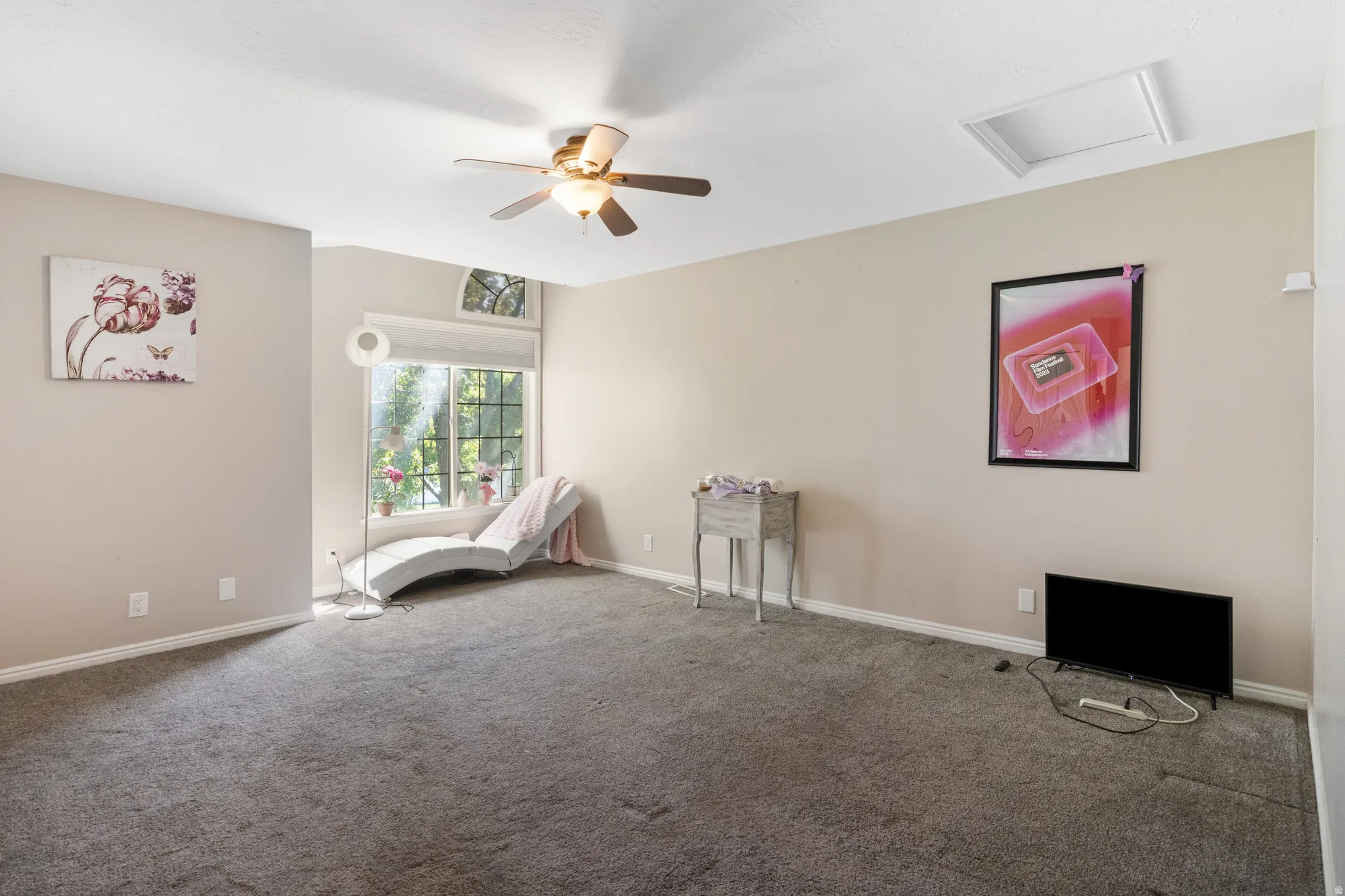 Carpeted room with a ceiling fan, transom window, and a white framed access panel