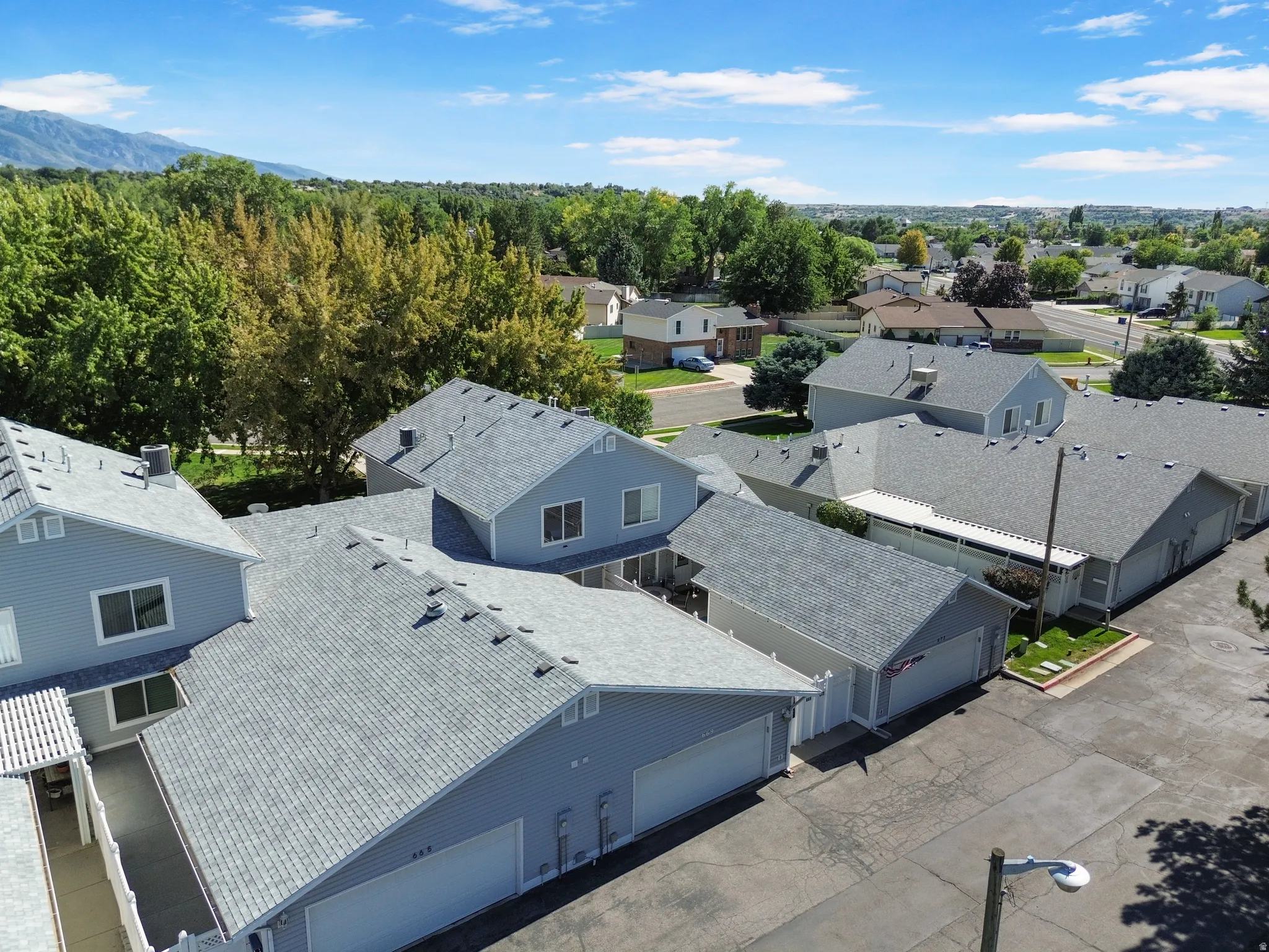 Multiple attached units featuring light blue siding and gray shingle roofing