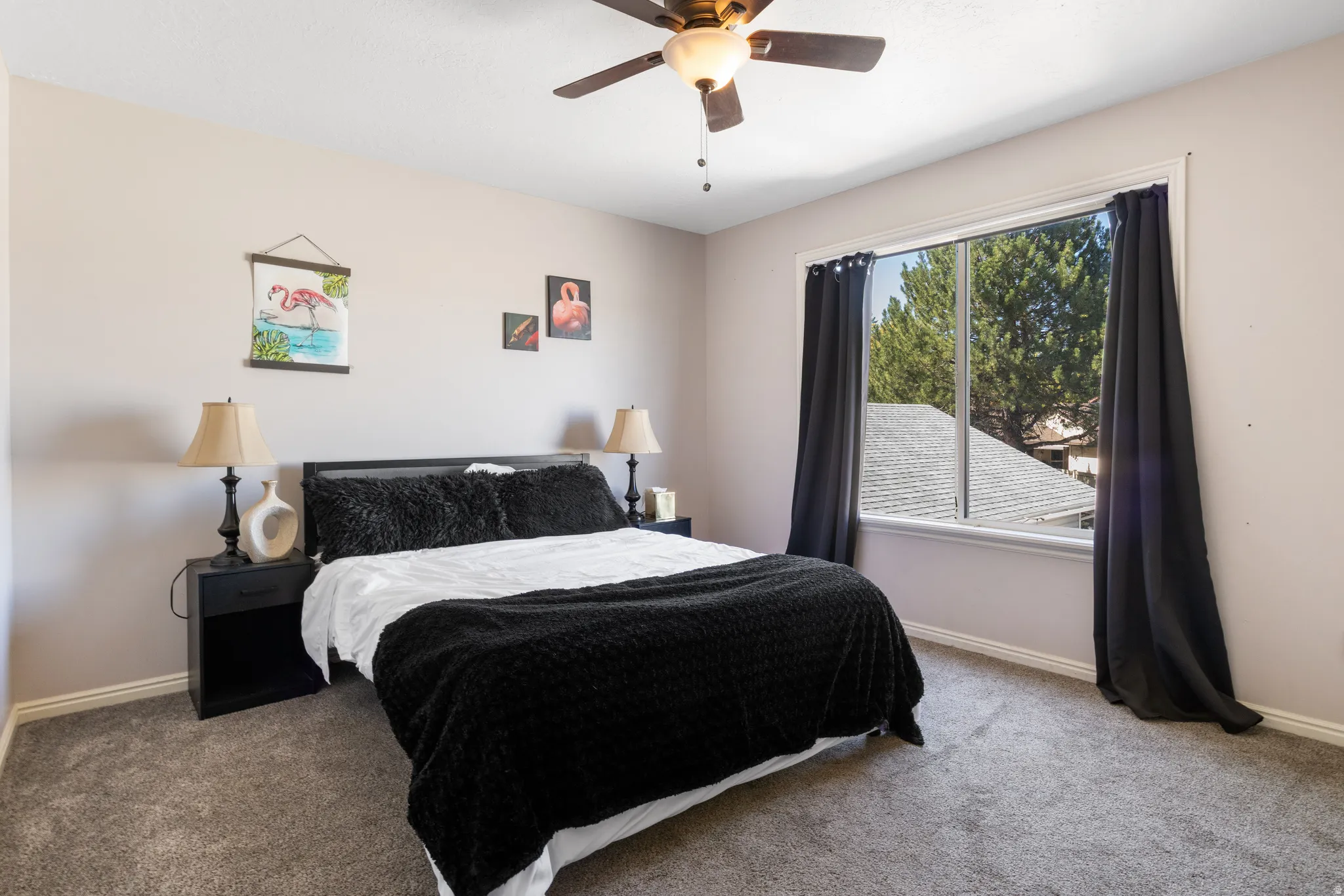 Wall-to-wall carpeting, a wood-finish ceiling fan, and a large window with white trim
