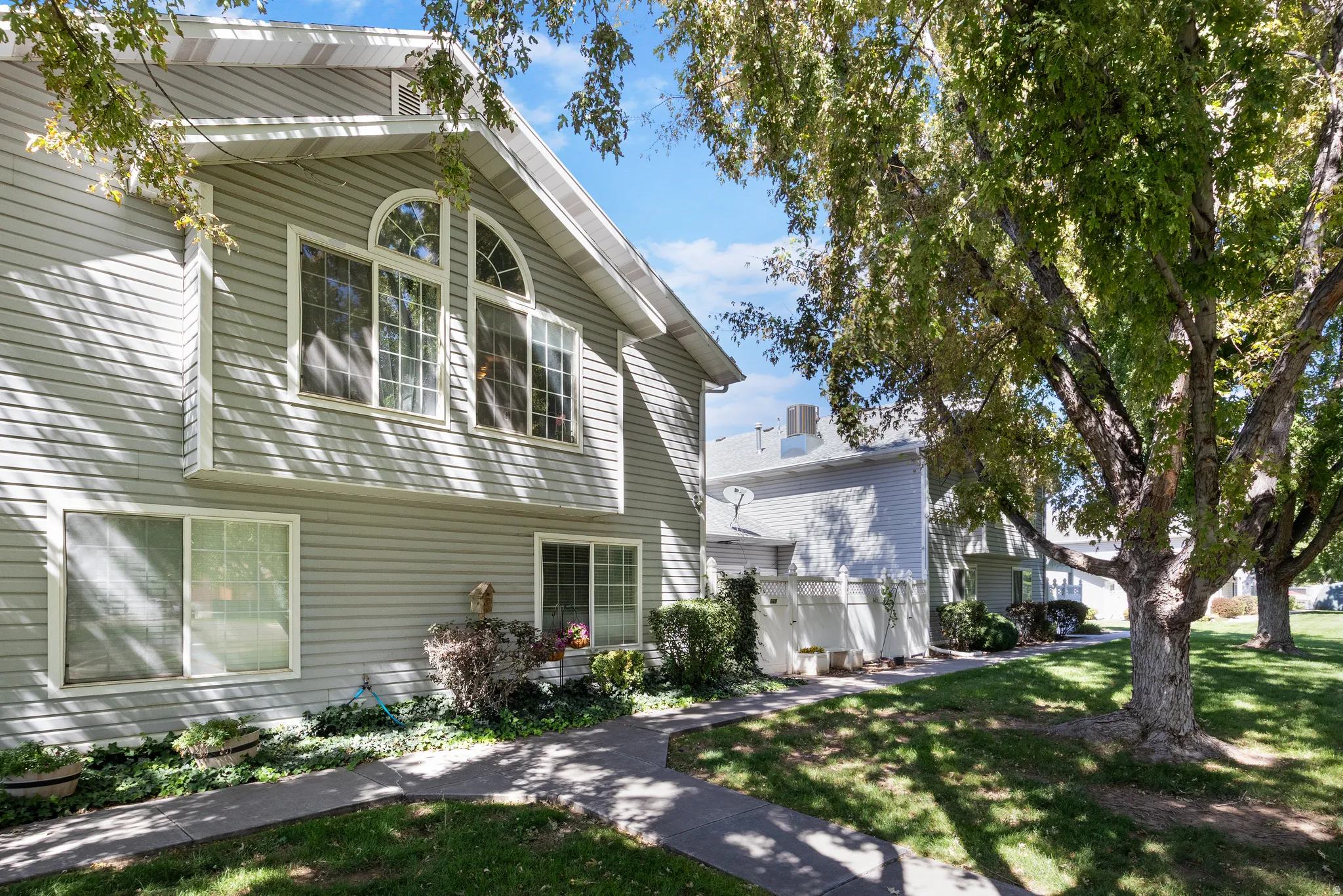 Siding exterior with multiple window styles, including arched and rectangular grid windows