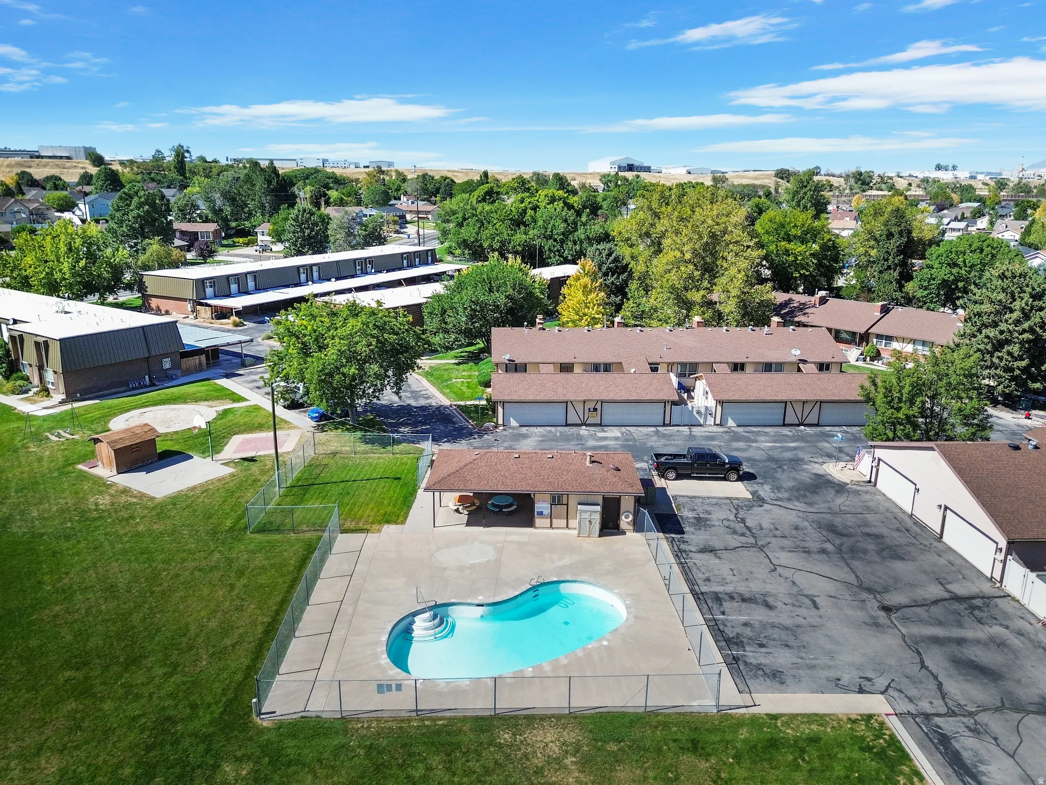 Community amenities include a fenced swimming pool, adjacent pool house, and shared grassy areas