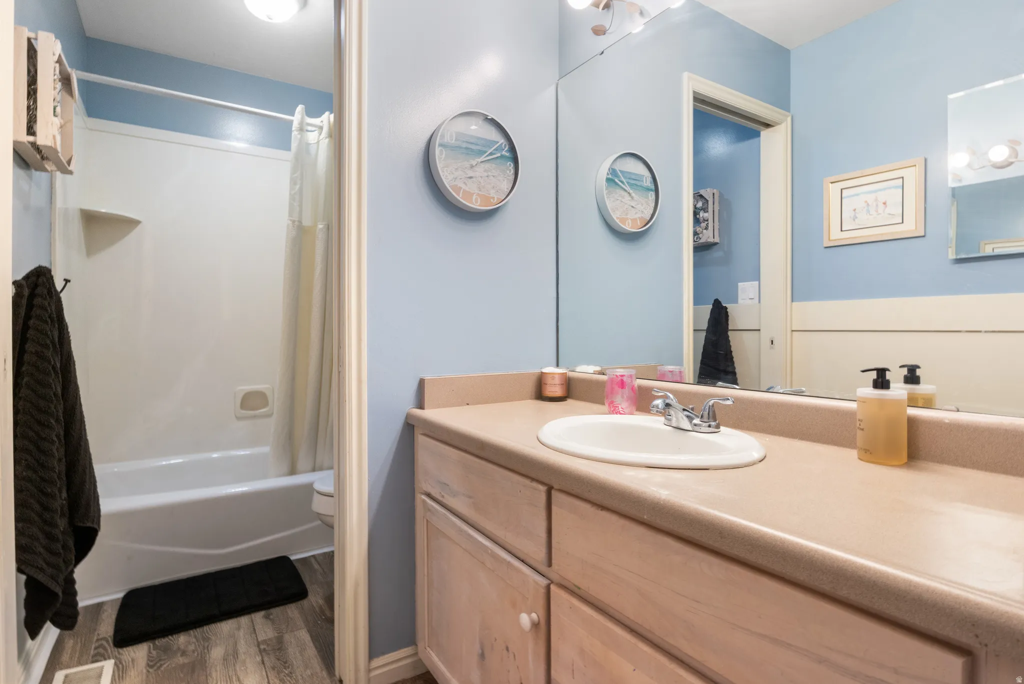 Vanity with integrated sink, chrome faucet, and expansive mirror
