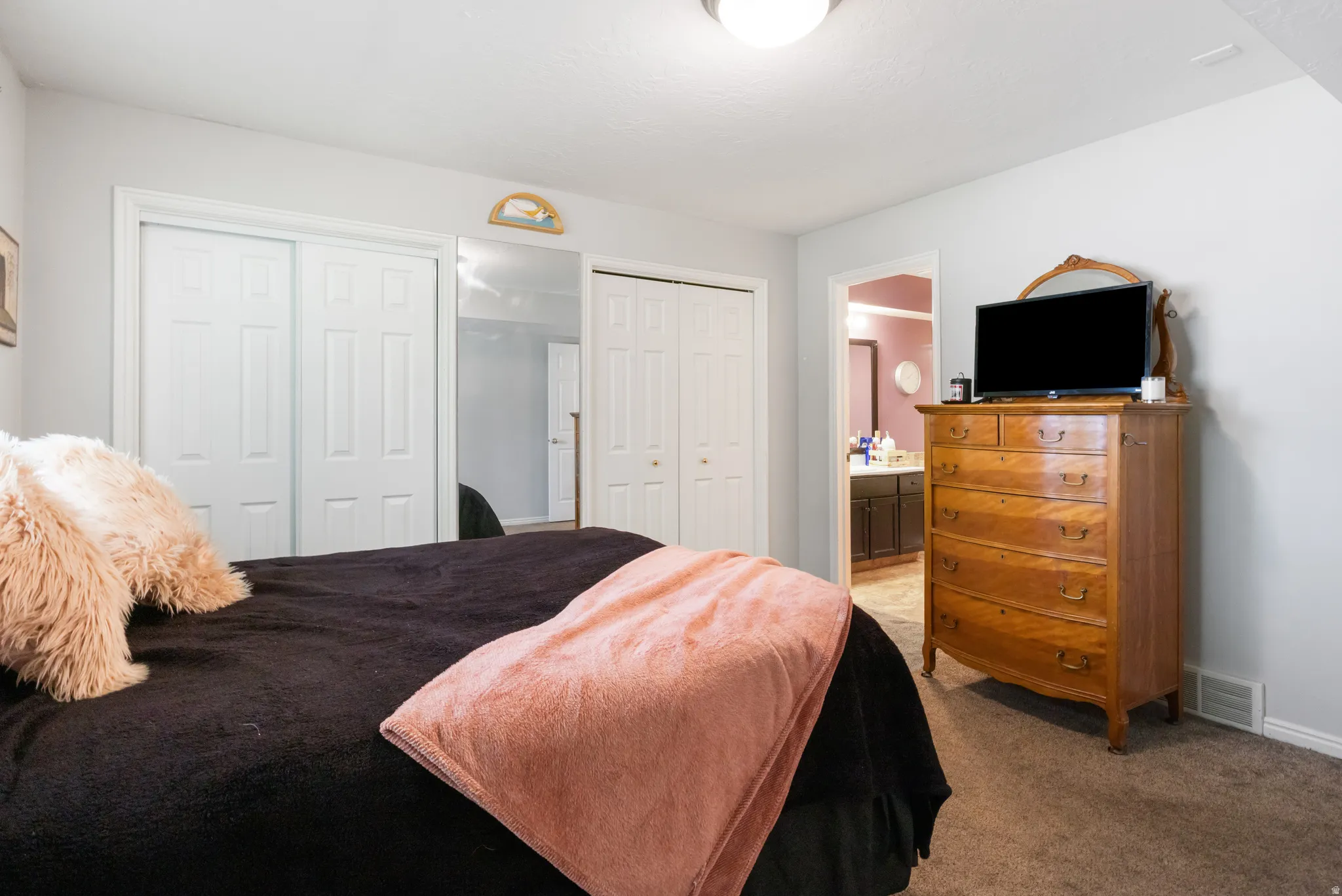 Soft neutral wall color, carpeted flooring, and a flush mount ceiling light