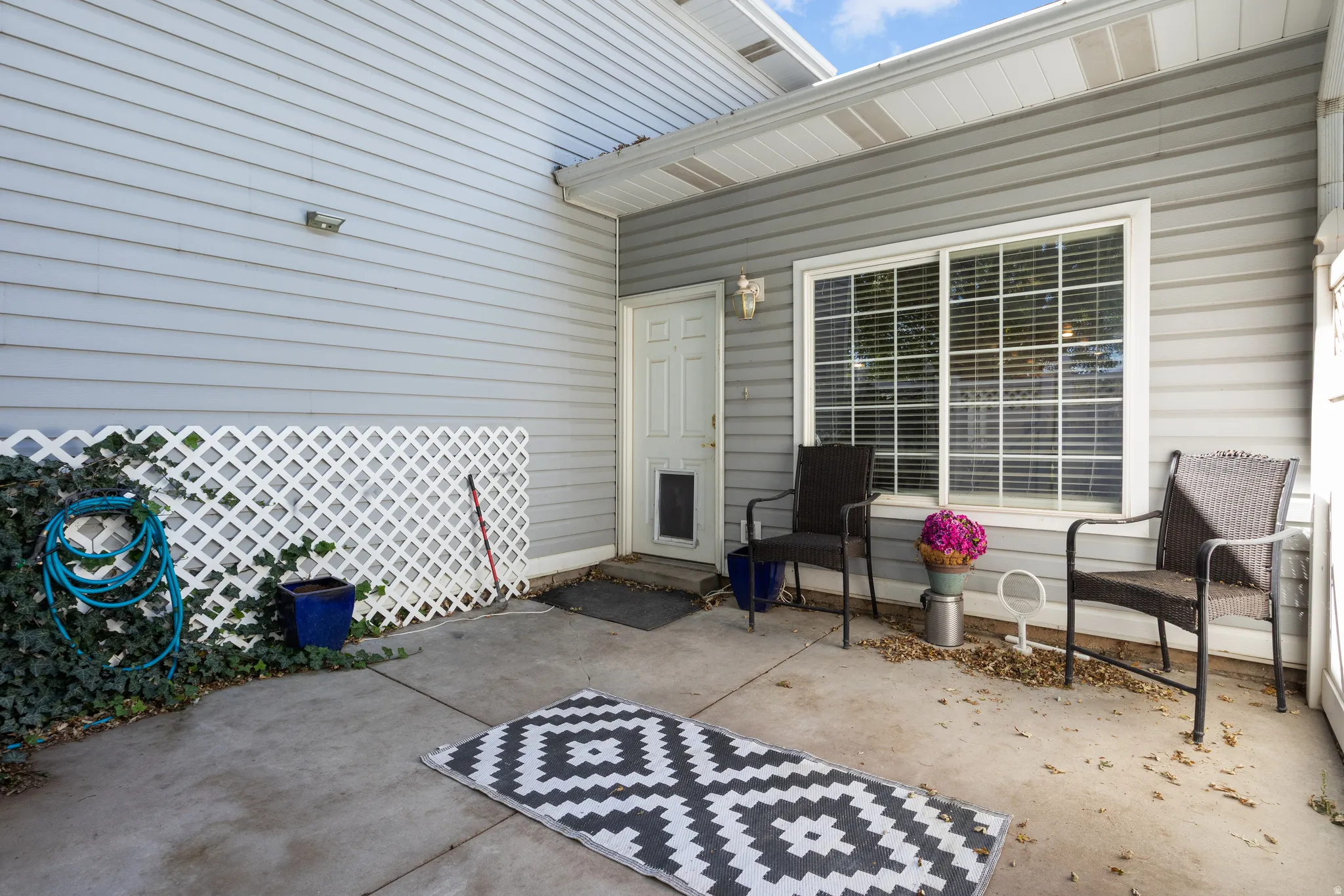 Private patio featuring concrete flooring and a white lattice wall