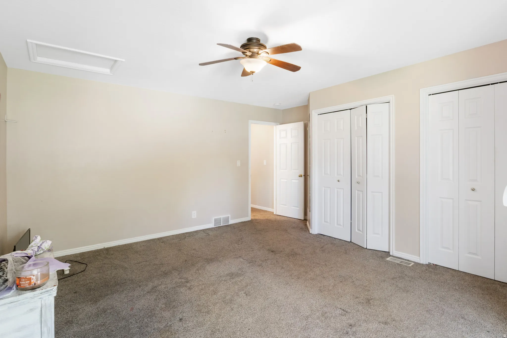 Wall-to-wall carpeting with multiple built-in closets and a ceiling fan