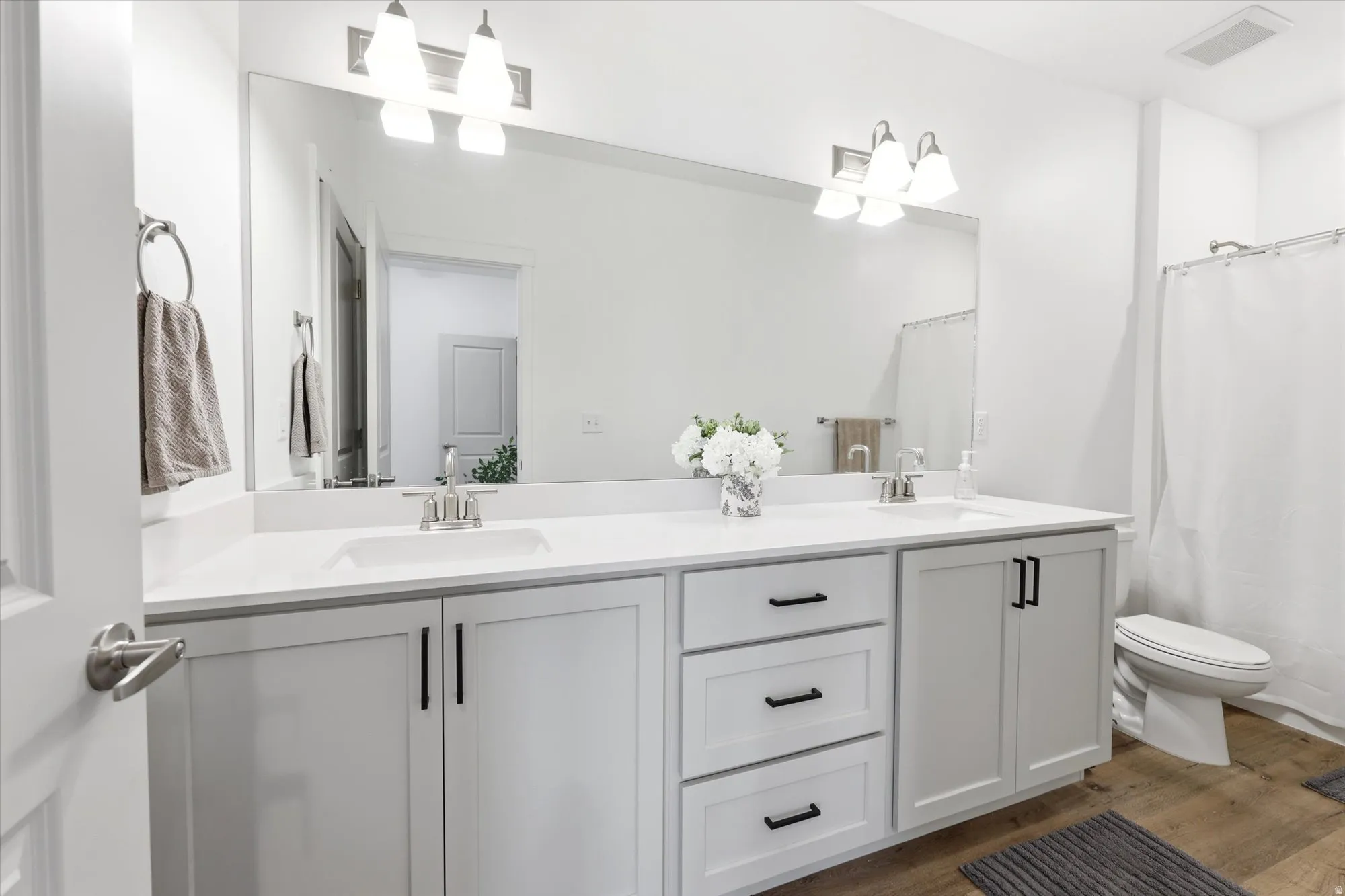 Double vanity with white countertops, undermount sinks, and chrome-finish faucets