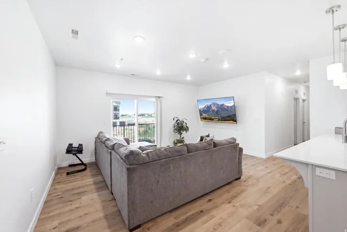 Wood-finish flooring throughout, recessed lighting, and a sliding glass door