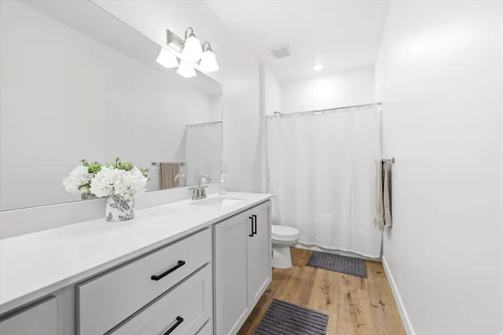 Bathroom featuring a light gray vanity with black hardware, white countertop, and an undermount sink