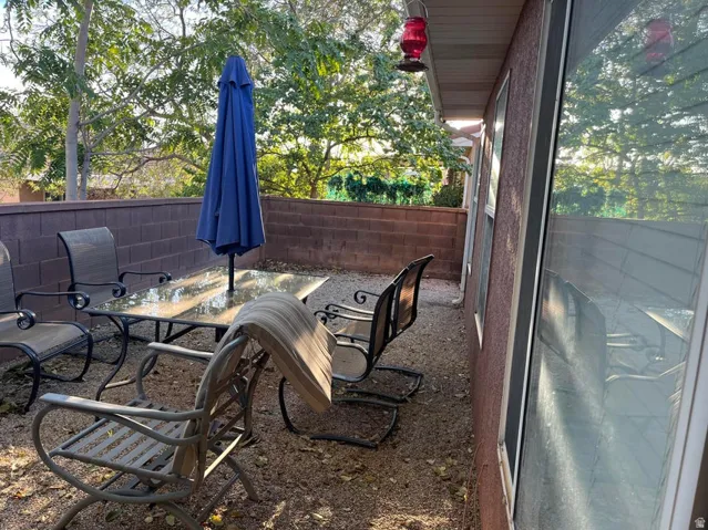 Private outdoor patio space featuring a block privacy wall and mature trees