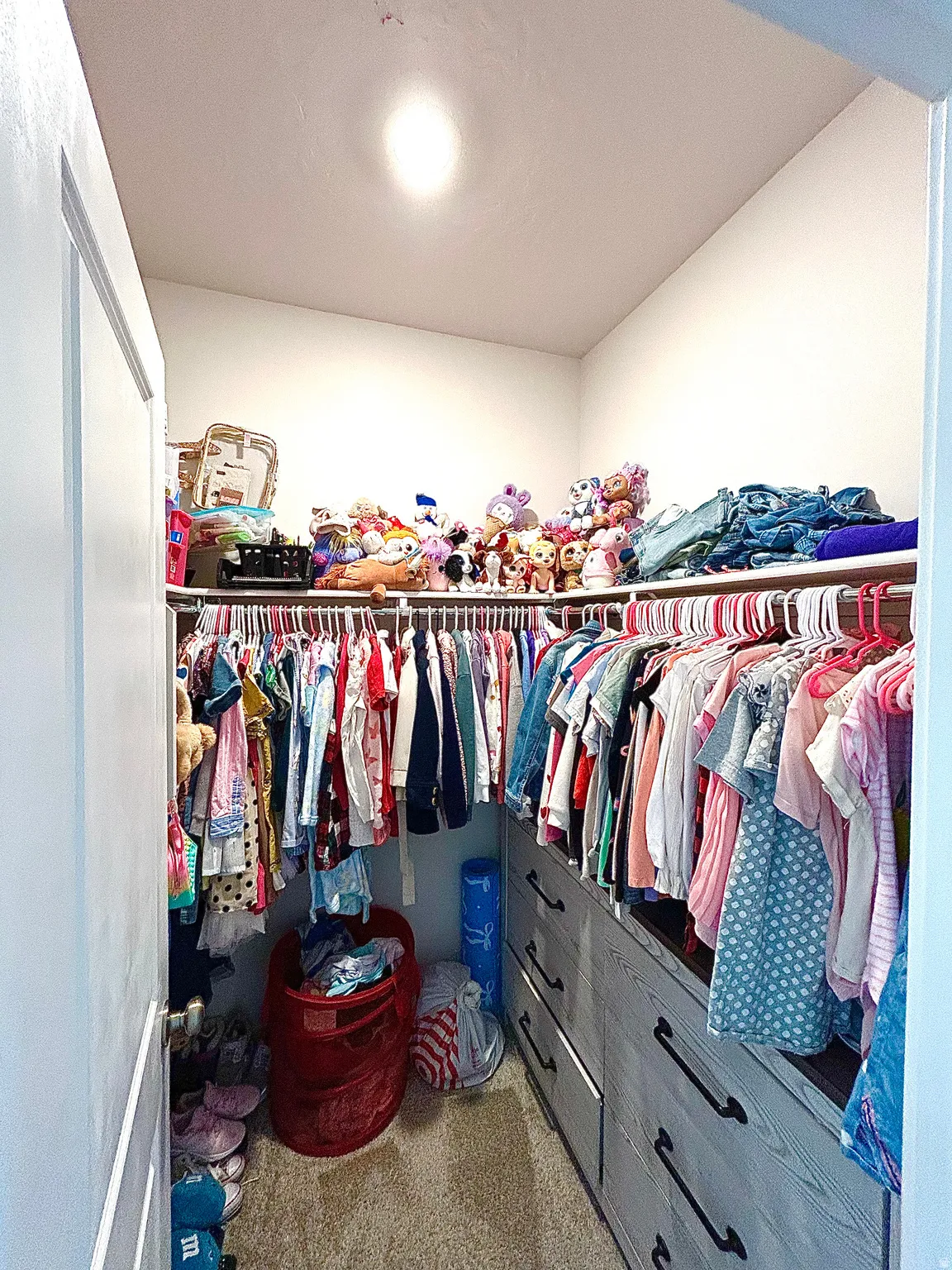 Built-in closet system featuring multiple hanging rods, integrated drawer storage with dark hardware, and upper shelving