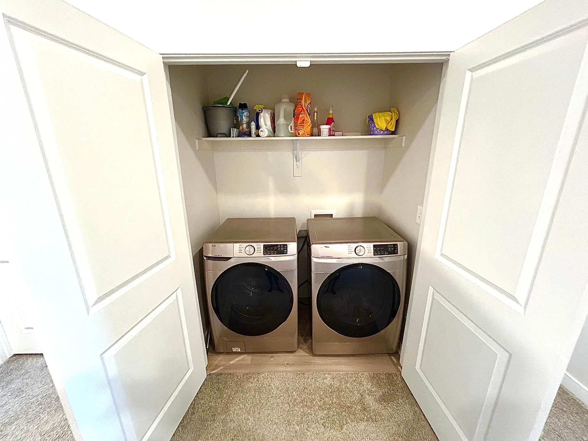 Laundry closet with bifold doors, integrated shelving, and appliance hookups