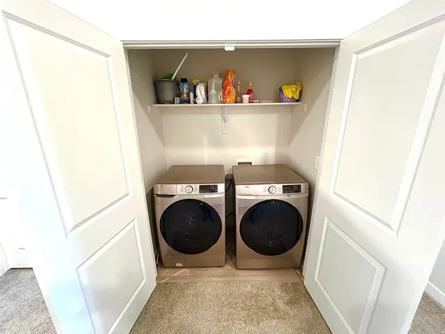 Laundry closet with bifold doors, integrated shelving, and appliance hookups