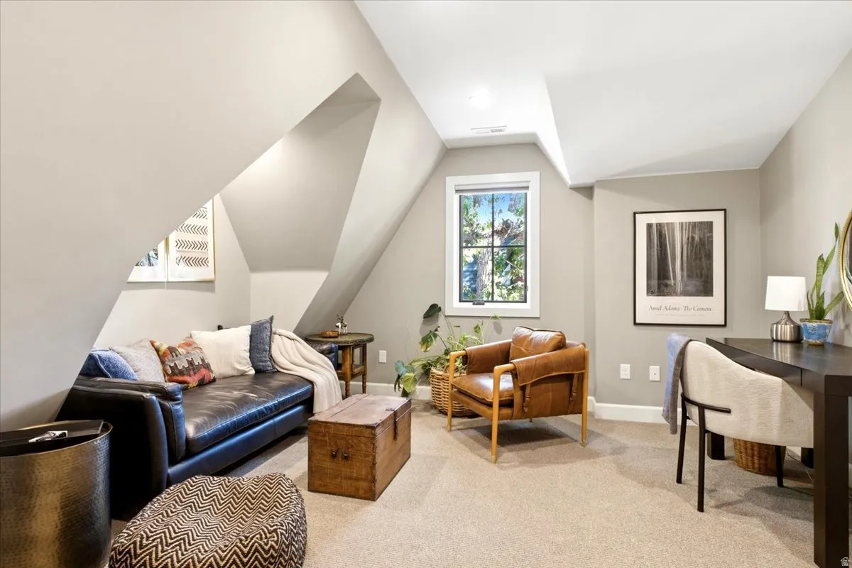 Carpeted room with sloped ceilings, recessed lighting, and a double-pane window