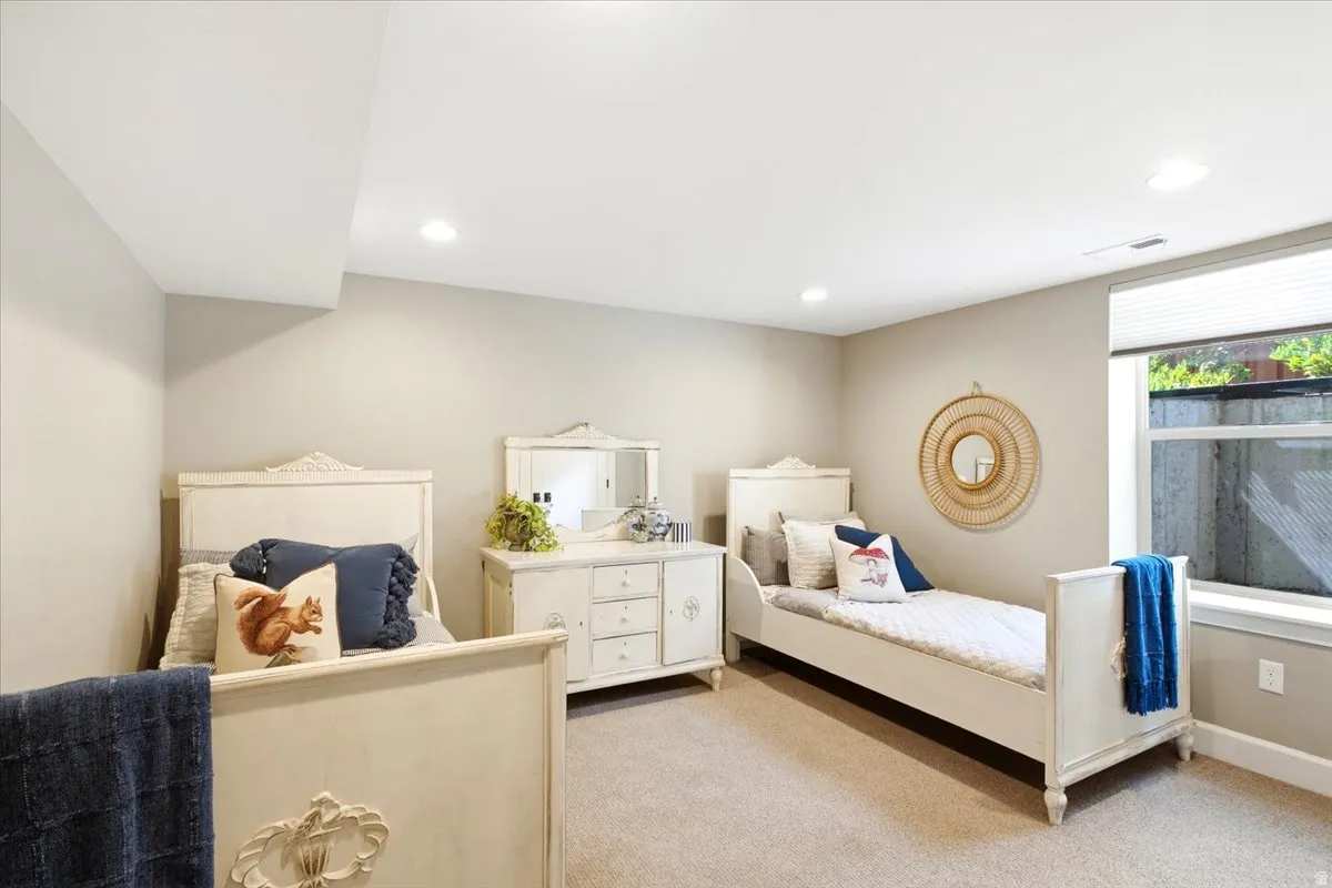 Recessed lighting illuminates neutral-toned walls and carpeted flooring