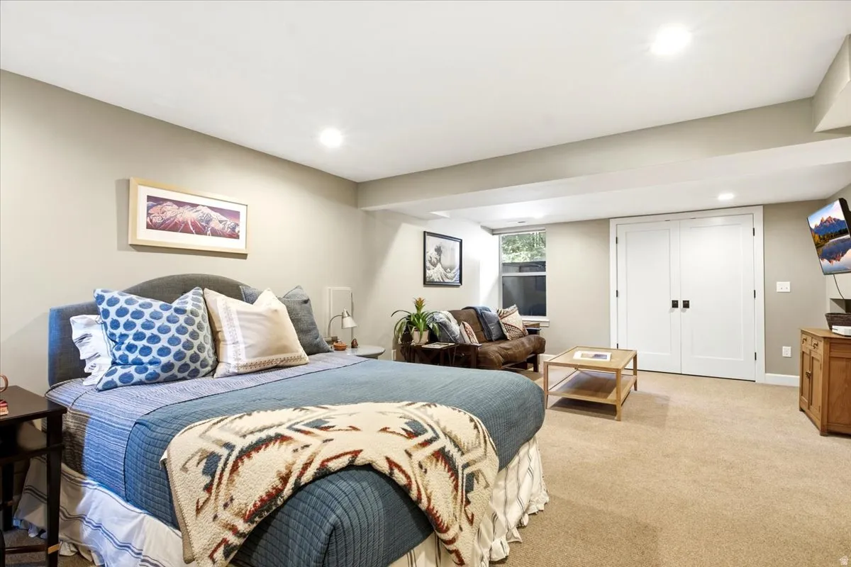 Carpeted room featuring recessed lighting, a window, and double white paneled doors with dark hardware