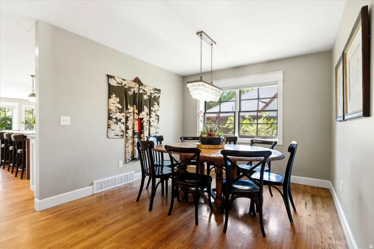 Hardwood flooring, crisp white trim, and a decorative chandelier