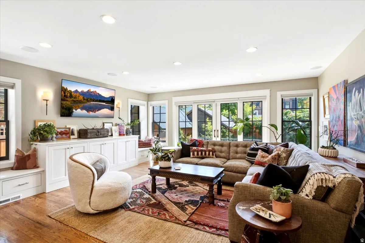 Hardwood flooring, built-in cabinetry, recessed lighting, and ample natural light from multiple windows
