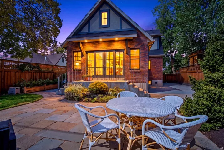 Brick exterior with a gabled roofline, complemented by French doors opening to a raised patio