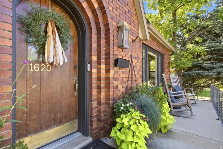 Brick exterior with an arched entry, wood-paneled door, and a concrete patio
