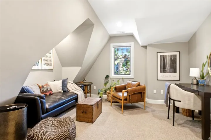 Carpeted room with sloped ceilings, recessed lighting, and a double-pane window