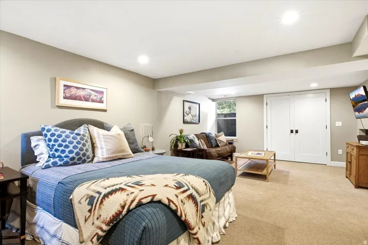 Carpeted room featuring recessed lighting, a window, and double white paneled doors with dark hardware