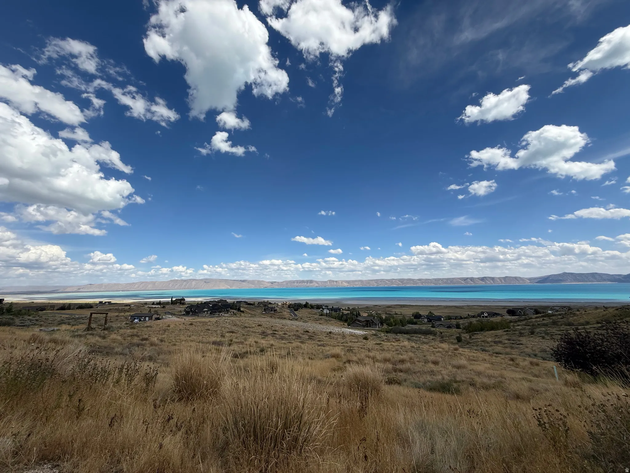 Expansive sky, distant body of water, and natural landscape