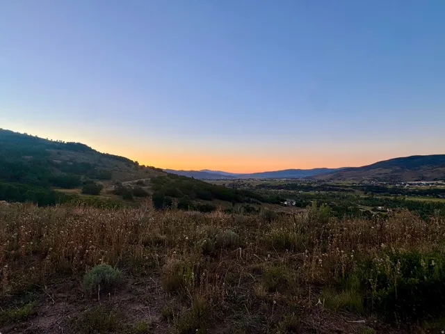 Expansive natural landscape with rolling hills and distant valley scenery